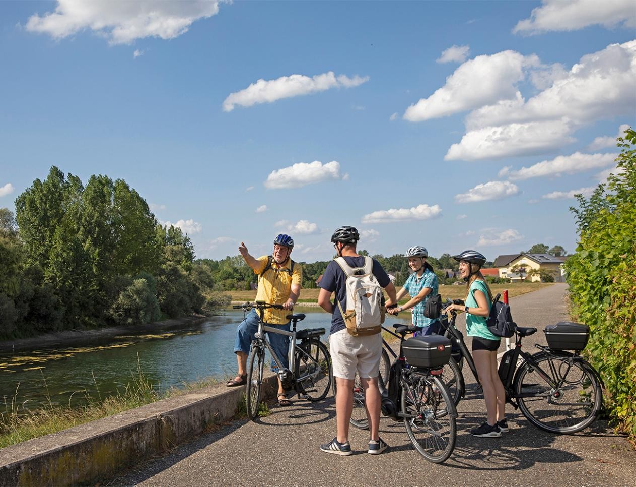 Eine Gruppe Radfahrer macht Pause am Rheindamm bei Plittersdorf