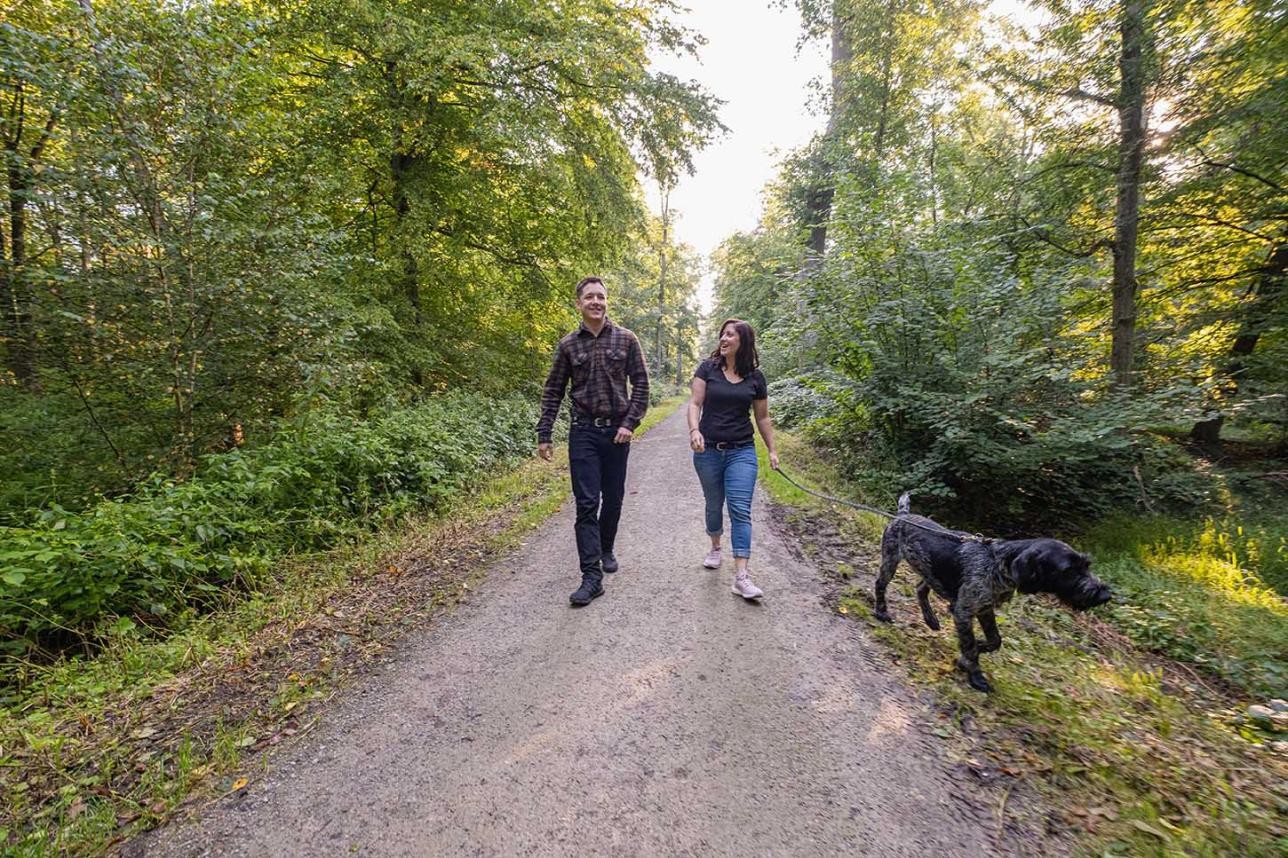 Spaziergänger mit Hund im Stadtwald in Rastatt