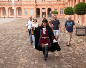 Mann im historischen Kostüm bei einer Führung im Schlosshof