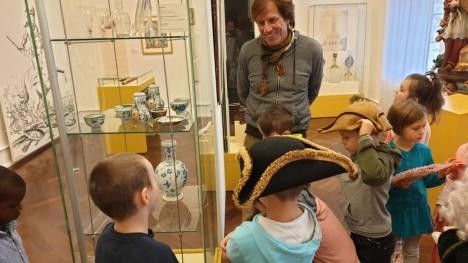 Museum educator Eric Schütt surrounded by curious children in the Rastatt City Museum.